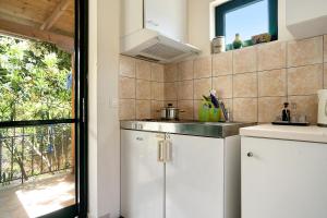a kitchen with white cabinets and a sink and a window at Vardia studio B in Mikros Gialos