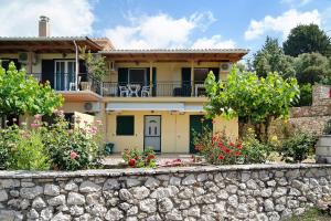 a house with a stone wall in front of it at Vardia studio B in Mikros Gialos