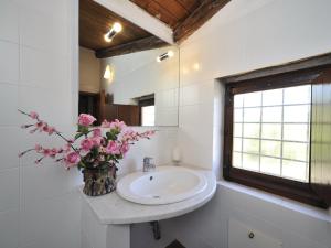 a bathroom with a sink and a vase of pink flowers at Finca Fiori 1 in Is Molas  +37 photos