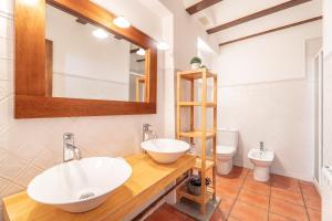 a bathroom with a sink and a mirror and a toilet at Cueva Del Gollisno in Chulilla +17 photos