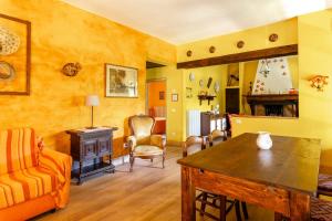 a living room with yellow walls and a wooden table at Tramonto al Rifugio Arcobaleno in Popiglio