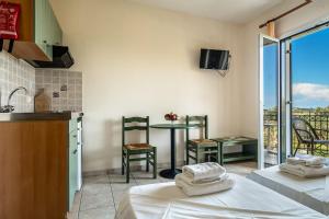 a room with a kitchen and a table with a balcony at Anemona studio D in Kefallonia