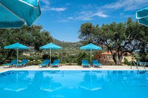 a swimming pool with blue chairs and umbrellas at Anemona studio D in Kefallonia +12 photos