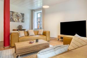 a living room with two couches and a flat screen tv at Suite mit Wintergarten in Dedelstorf