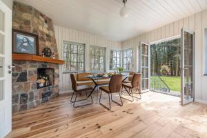 a dining room with a stone fireplace and a table and chairs at Suite mit Wintergarten in Dedelstorf