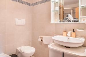 a bathroom with a white sink and a toilet at Vorderschöneck 2 in Longostagno +8 photos