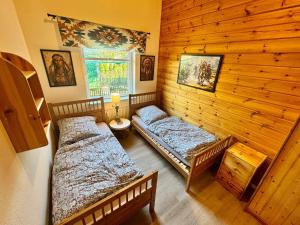 a room with two beds in a wooden room at Tiny Rooster Lodge in Alt Duvenstedt
