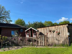 a wooden fence in front of a house at Tiny Rooster Lodge in Alt Duvenstedt