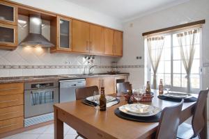 a kitchen with a wooden table and a dining room at A O - Ferrel House Casual in Ferrel