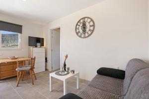 a living room with a couch and a clock on the wall at Fewo Arafo in Güimar