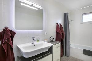 a white bathroom with a sink and a mirror at Fewo Arafo in Güimar +15 photos