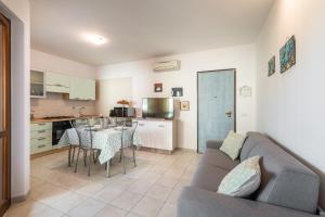 a living room with a couch and a table and a kitchen at Appartamento Isabel in Villasimius
