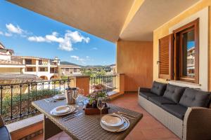 a patio with a couch and a table on a balcony at Appartamento Isabel in Villasimius