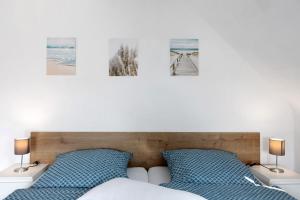 a bedroom with a bed with three pictures on the wall at Ferienwohnung en Verde in Felsberg