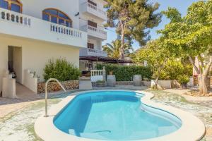 a swimming pool in front of a house at La Cabanya Apartment 3d in Canyamel