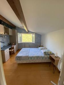 a bedroom with a large bed and a kitchen at Mas Les Coutilles in Cabrières-dʼAvignon