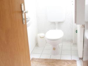 a white bathroom with a toilet and a sink at Haus zur Bienenweide in Schömberg