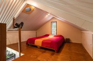 a bedroom with a bed in a attic at Harmony Creek - The Cottage in Cow Bay