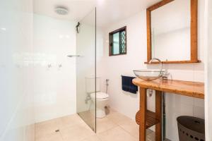 a bathroom with a sink and a glass shower at Harmony Creek - The Cottage in Cow Bay