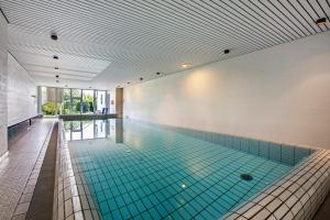 a large swimming pool with blue tiles on the ceiling at Fewo Waldfee in Höchenschwand