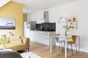 a kitchen and living room with a table and a couch at Strandroggen in Böhl +24 photos