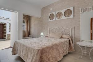 a bedroom with a white bed and a brick wall at Piso Río de Conil in Conil de la Frontera