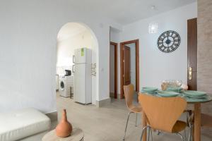 a kitchen and living room with a table and chairs at Piso Río de Conil in Conil de la Frontera