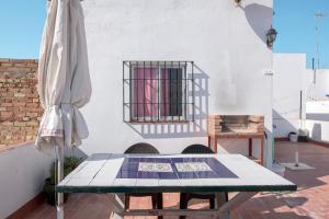 a table and a umbrella on a patio at Piso Río de Conil in Conil de la Frontera
