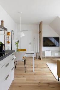 a kitchen with white cabinets and a white table at Strandroggen in Böhl