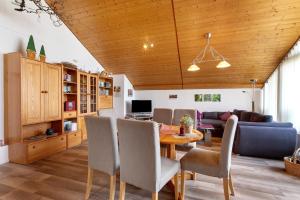 a dining room and living room with a wooden ceiling at Haus Müller in Böhringen