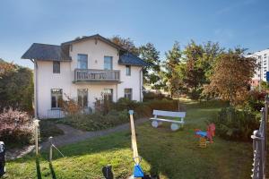 a house with a yard with a bench and a playground at Effi-Briest-Villa in Heringsdorf
