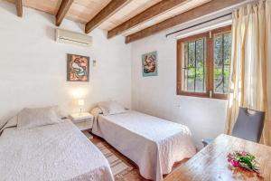 a bedroom with two beds and a window at Son Del Rio Nou in Pollença