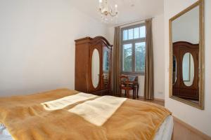 a bedroom with a bed and a large mirror at Effi-Briest-Villa in Heringsdorf