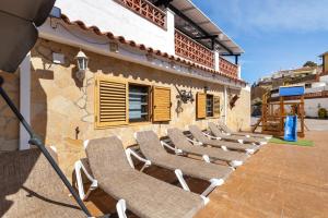 a row of chairs sitting outside of a building at Cal Ramon con piscina in Rubí