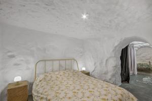 a bedroom with a bed in a white wall at Casa Cueva Rural, Calima in Juncalillo