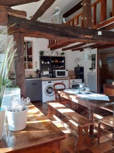 a kitchen with a table and chairs in a room at Maisonnette Cocooning en Sologne in Gy-en-Sologne