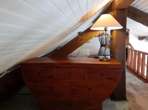 a lamp on top of a dresser in a attic at Maisonnette Cocooning en Sologne in Gy-en-Sologne