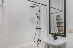 a bathroom with a shower and a sink and a mirror at Casa Cueva Rural, Calima in Juncalillo