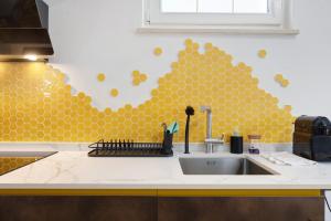 a kitchen with a sink and a wall covered in gold dots at Honey Home With Parking in Laives