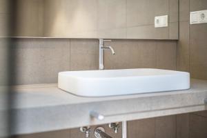 a white sink on a counter in a bathroom at Loft Lauben in Bressanone +11 photos