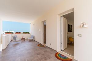a room with a hallway with a table and chairs at Le scuderie 10 in Galatone