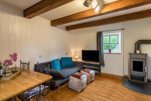 a living room with a couch and a tv at Zuhaus am See in Gstadt am Chiemsee