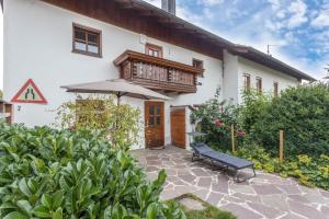 a patio in front of a white house with an umbrella at Zuhaus am See in Gstadt am Chiemsee
