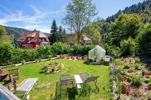 a garden with benches and a house in the background at Villa Sonnenwinkel in Todtmoos