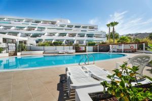 a hotel with a swimming pool and a building at Las Flores 407 in Playa Fañabe
