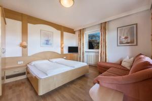 a bedroom with a bed and a couch at Residence Kronstein - Fewo 3 in Tesimo