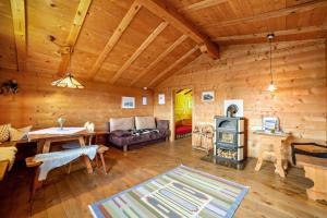 a living room with a fireplace in a log cabin at Ferienhaus Rauchegg - Bergblick in San Pancrazio dʼUltimo