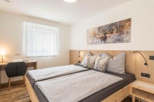 a bedroom with a large bed with a desk at Apartment Roderer in Völs am Schlern