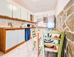a kitchen with white cabinets and a table and chairs at Il Borgo 4 in Capoliveri