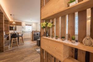 a kitchen and living room with wooden walls and wooden floors at Apartment Roderer in Völs am Schlern